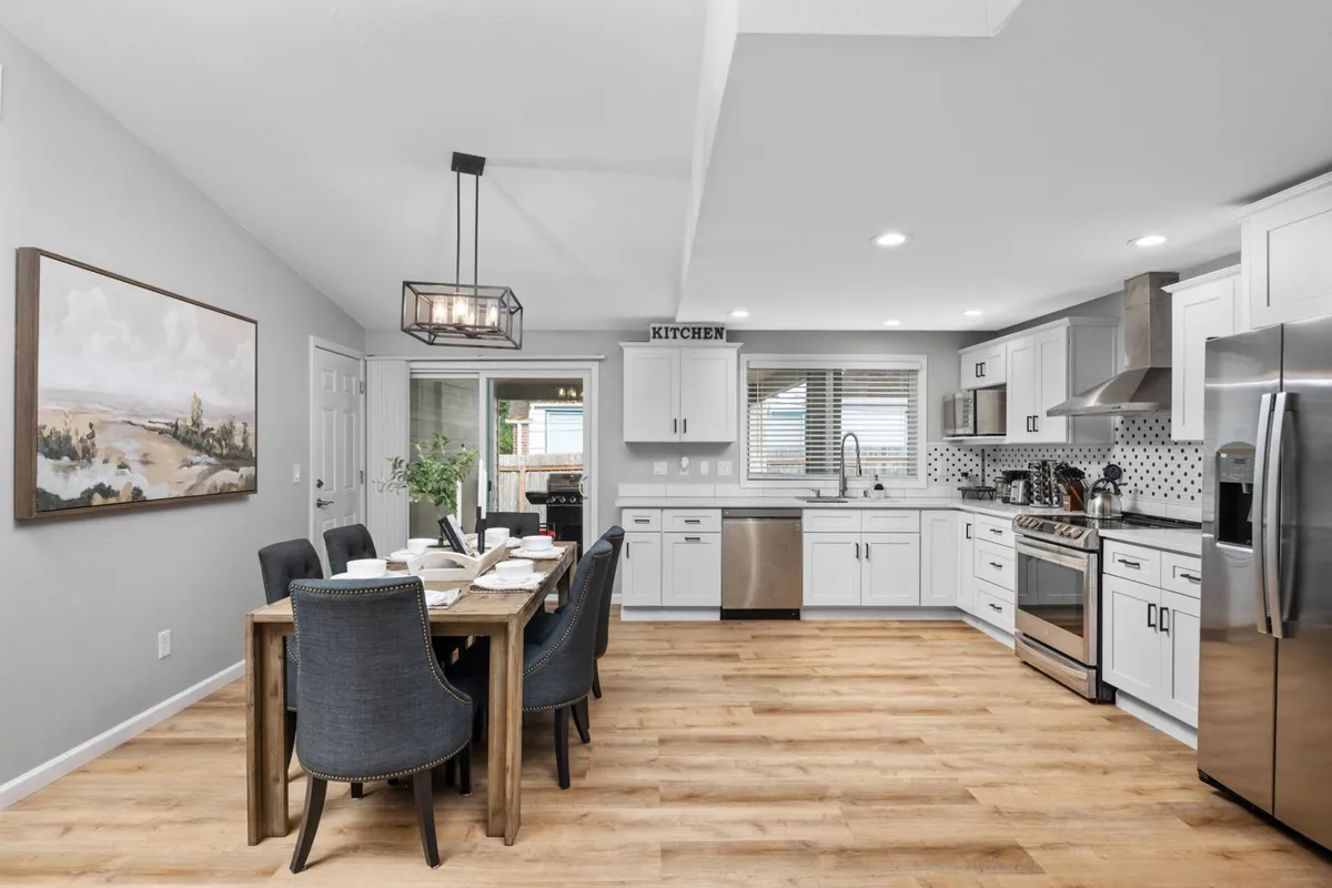 An inviting dining area with a spacious dining table, a kitchen island, and vibrant artwork on the wall. The open-plan layout supports group meals, lively conversations, and makes it easy to gather before or after exploring the city.