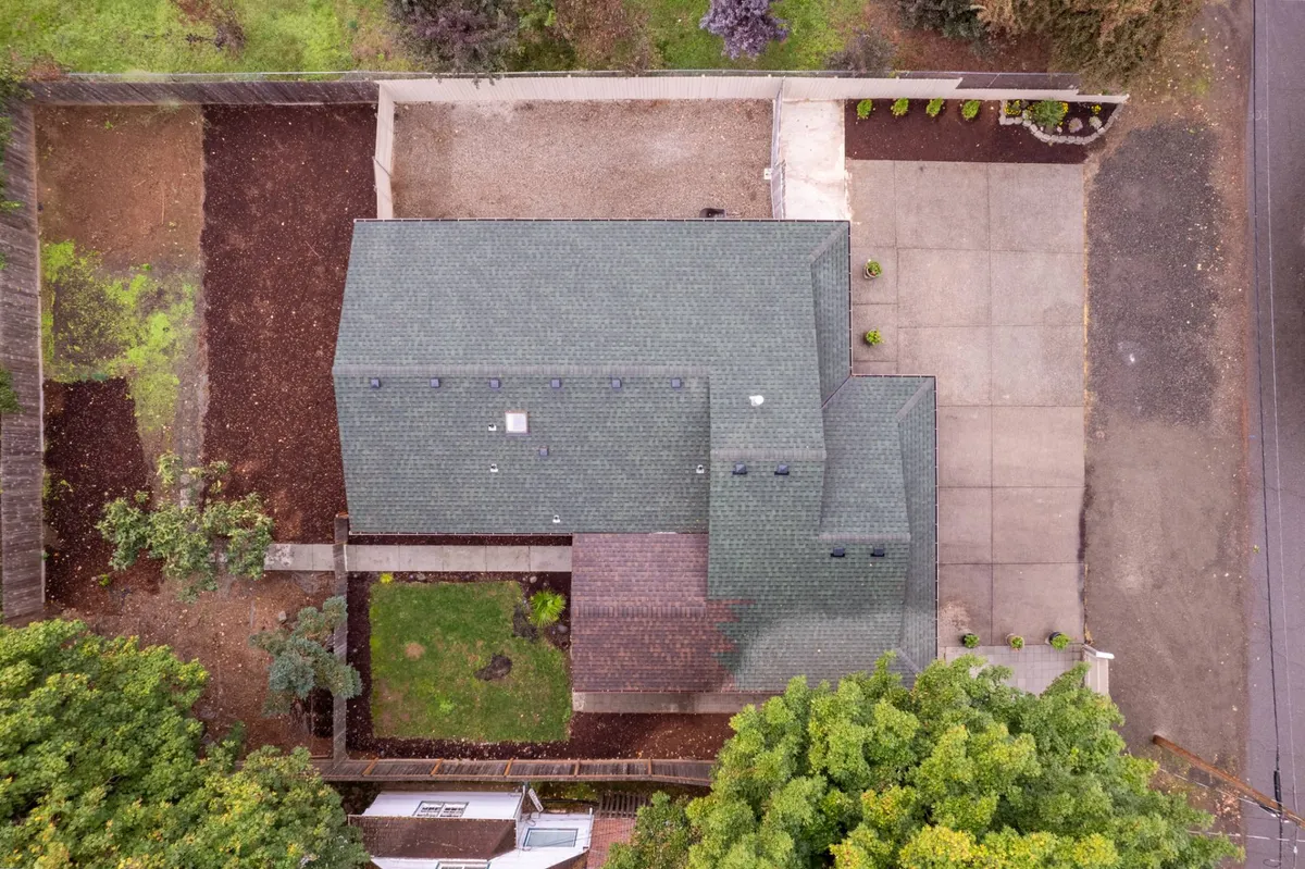 Here we see a landscaped exterior with a clear view of both the yard and a cozy patio area, framed by well-tended plants and open space. The fenced boundary is visible, reinforcing a sense of privacy and peace of mind for both children and pets. The tranquil mood invites quiet moments or playful afternoons alike.